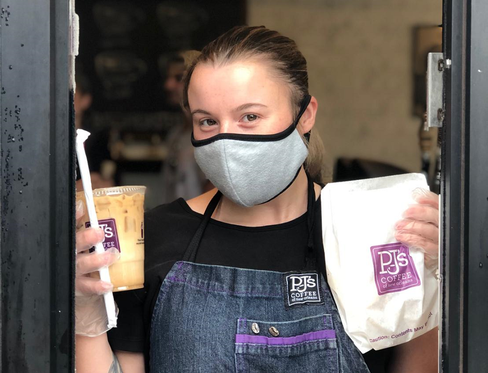 PJ's employee wearing mask and holding a pastry bag and iced coffee